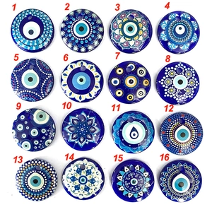 Détail de seize breloques en verre œil grec bleu assorties pour création de bijoux DIY