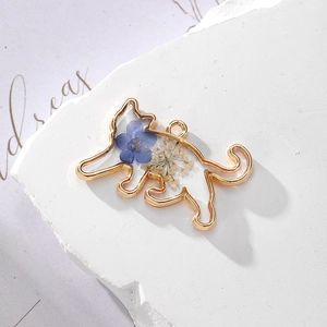 Detailed view of cat-shaped alloy pendant with real dried flowers and resin filling