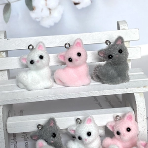 Detail van schattige gevlokte mini kattenhangers in wit roze en grijs voor DIY-sieraden