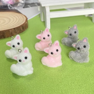Detail van schattige gevlokte mini-kattenhangers in wit, roze en grijs met metalen ringen