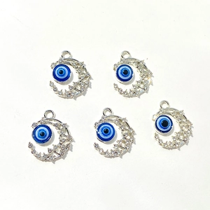 Vue détaillée de 5 pendentifs lune argentés avec yeux bleus et strass pour bijoux DIY