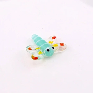 Detailed macro shot of a handcrafted light green glass dragonfly bead for DIY jewelry