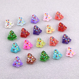 Dettaglio di perline a forma di albero di Natale colorate a pois per gioielli fai-da-te