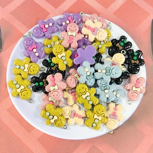 Colorful cartoon gingerbread man charms for DIY jewelry and keychain making in a bowl