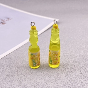 Macro shot of 3D pineapple soda resin pendants with metal loops for DIY jewelry making