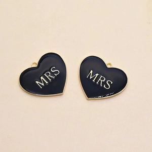 Nahaufnahme schwarzer Herzanhänger mit MRS-Schriftzug und Goldemaille für DIY-Schmuck