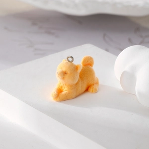 Detail of a yellow flocked Shiba Inu charm with a silver ring on a minimalist stand