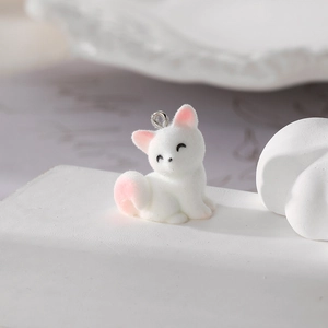 Macro detail of a white flocked kitten pendant featuring soft texture and pink accents