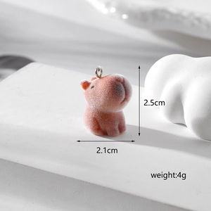 Macro shot of a pink flocked capybara charm showing 2.5cm height and 2.1cm width details