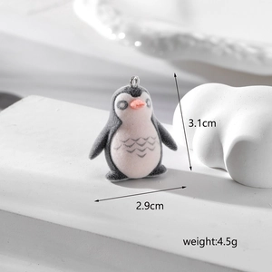 Detailed view of flocked penguin pendant with dimensions 3.1cm height and 2.9cm width