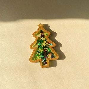 Detail of wooden Christmas tree pendant with colorful sequins and hanging hole design