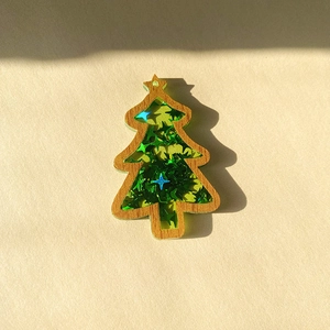 Close-up of wood Christmas tree pendant filled with green star sequins for DIY crafts