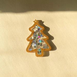 Detail of Christmas tree pendant with wood texture frame and laser star sequins
