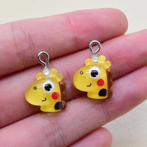Nahaufnahme von niedlichen Giraffen-Anhängern aus Harz mit gelbem Finish für DIY-Schmuck