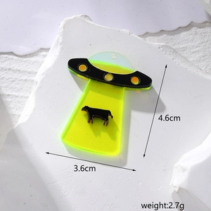 Macro detail of UFO cow abduction acrylic charm showing 4.6cm height and weight specs