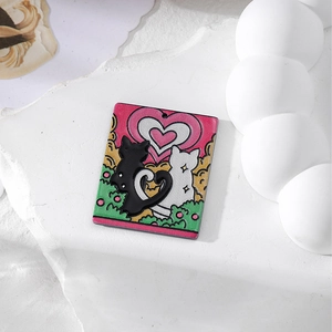 Detail von Acryl-Katzenanhängern mit Herzschwänzen und rosa Hintergrund für DIY-Schmuck
