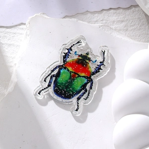 Detailed macro of colorful acrylic beetle pendants with glitter finish and pre-drilled holes