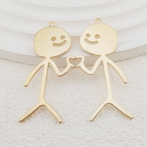 Detail of golden stickman heart pendants showing the smooth metallic finish and hanging loops