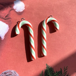Detail of two Christmas candy cane pendants with red, white and green stripes for DIY jewelry