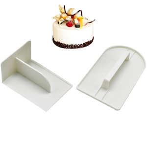 Two-piece white plastic cake scraper set for smoothing cream on cakes with strawberry decor