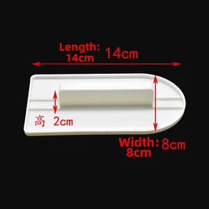 Detailed macro view of white plastic cake scraper showing 14cm by 8cm dimensions