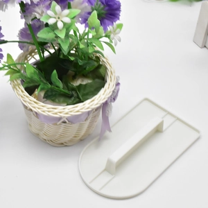 Close-up of a white plastic cake smoother with handle for smoothing cream and fondant