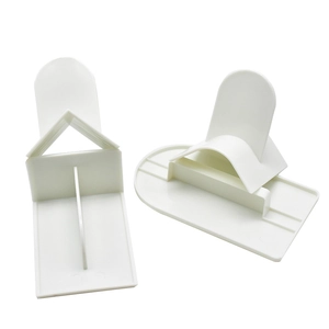 Detailed view of white plastic cake scrapers with triangle and semicircle smoothers
