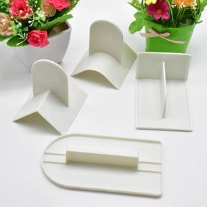 Detailed set of four white plastic cake scrapers and fondant smoothers for baking DIY