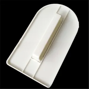 White plastic cake scraper smoother with handle for baking on a plain black background