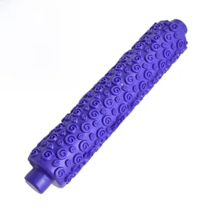 Close-up of a purple plastic rolling pin with spiral scroll pattern for fondant embossing