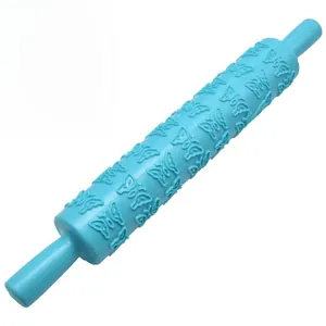 Detail of blue plastic rolling pin featuring embossed butterfly patterns for cake DIY