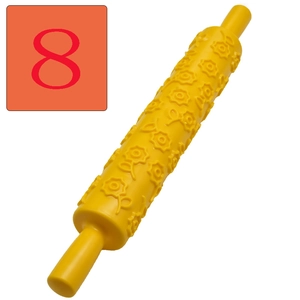 Macro detail of yellow plastic rolling pin with embossed floral patterns for DIY fondant baking