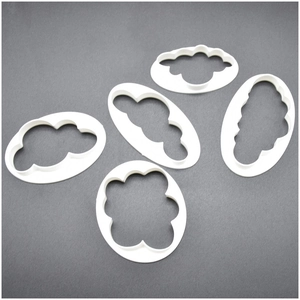 Set of 5 white plastic cloud-shaped clay cutters and cookie molds on grey background