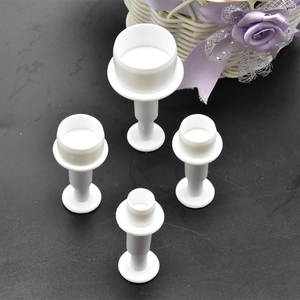 Macro detail of 4 white plastic spring plunger fondant cutters in different sizes