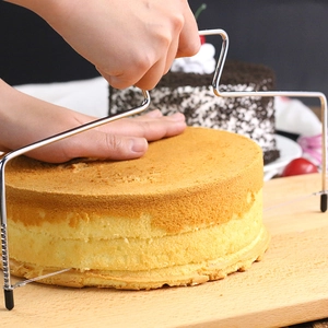 Adjustable stainless steel cake slicer cutting even layers through yellow sponge cake