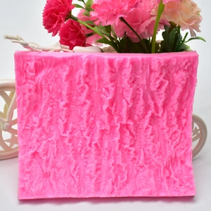 Detailed view of pink silicone mold featuring a textured tree bark and rock surface pattern