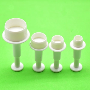 Set of four white plastic plunger cutters for fondant and cookie baking in various sizes