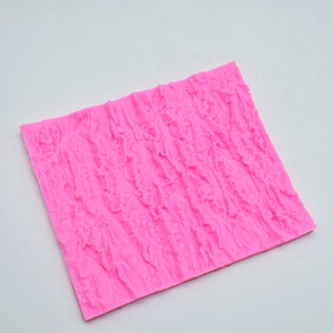 Macro detail of flexible pink silicone mold featuring realistic tree bark and rock textures