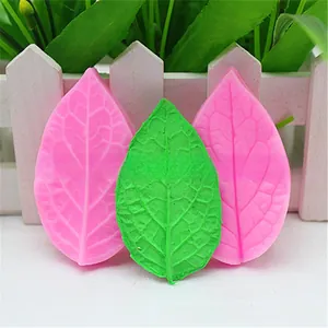 Close-up of leaf-shaped silicone fondant molds showing detailed vein textures