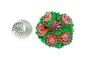 Détail d'une douille de pâtisserie en acier inoxydable avec une fleur en crème colorée