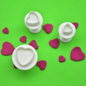 Close-up of three heart-shaped spring plunger cutters for fondant and cookie DIY