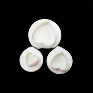 Detailed view of three heart-shaped spring plunger cookie cutters for fondant baking