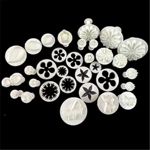 Detailed set of white spring-loaded cookie plungers in floral and geometric shapes
