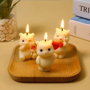 Three cute white bear aromatherapy candles with red heart and flower in cozy home setting