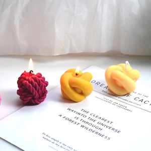 Creative knot and yarn ball scented candles in vibrant pink and yellow colors