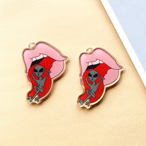 Detail van acryl tonghanger met alien-grafiek en roze lippen voor doe-het-zelf sieraden
