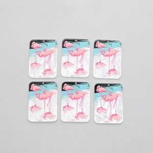 Détail de six pendentifs flamants roses en acrylique rectangulaires avec trous de suspension