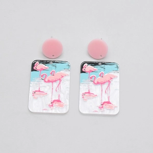 Détail de boucles d'oreilles en acrylique avec flamants roses et clous arrondis