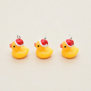 Three mini resin Christmas yellow duck pendants with red hats and silver metal rings