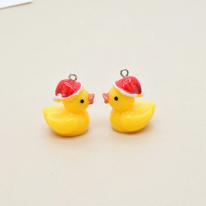 Macro shot of two yellow resin Christmas ducks with red hats and metal loops